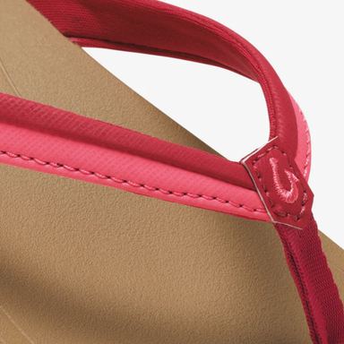 Close-up of a sandal with red straps on a beige background