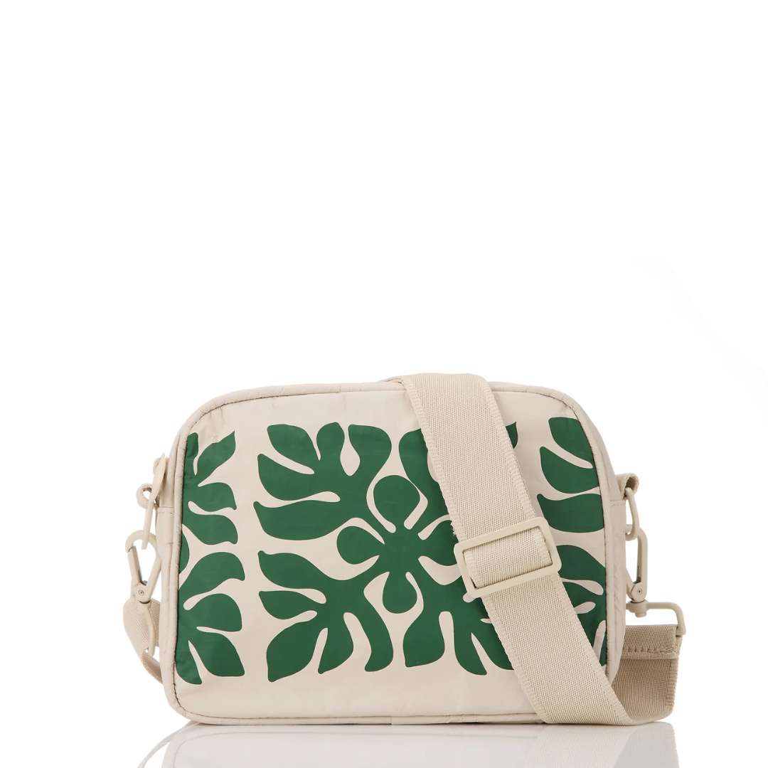 Beige crossbody bag with green leaf pattern on a white background