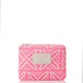 A pink zip-around pouch with a cream geometric tribal pattern and a cream leather brand patch on the front, shown against a plain white background.