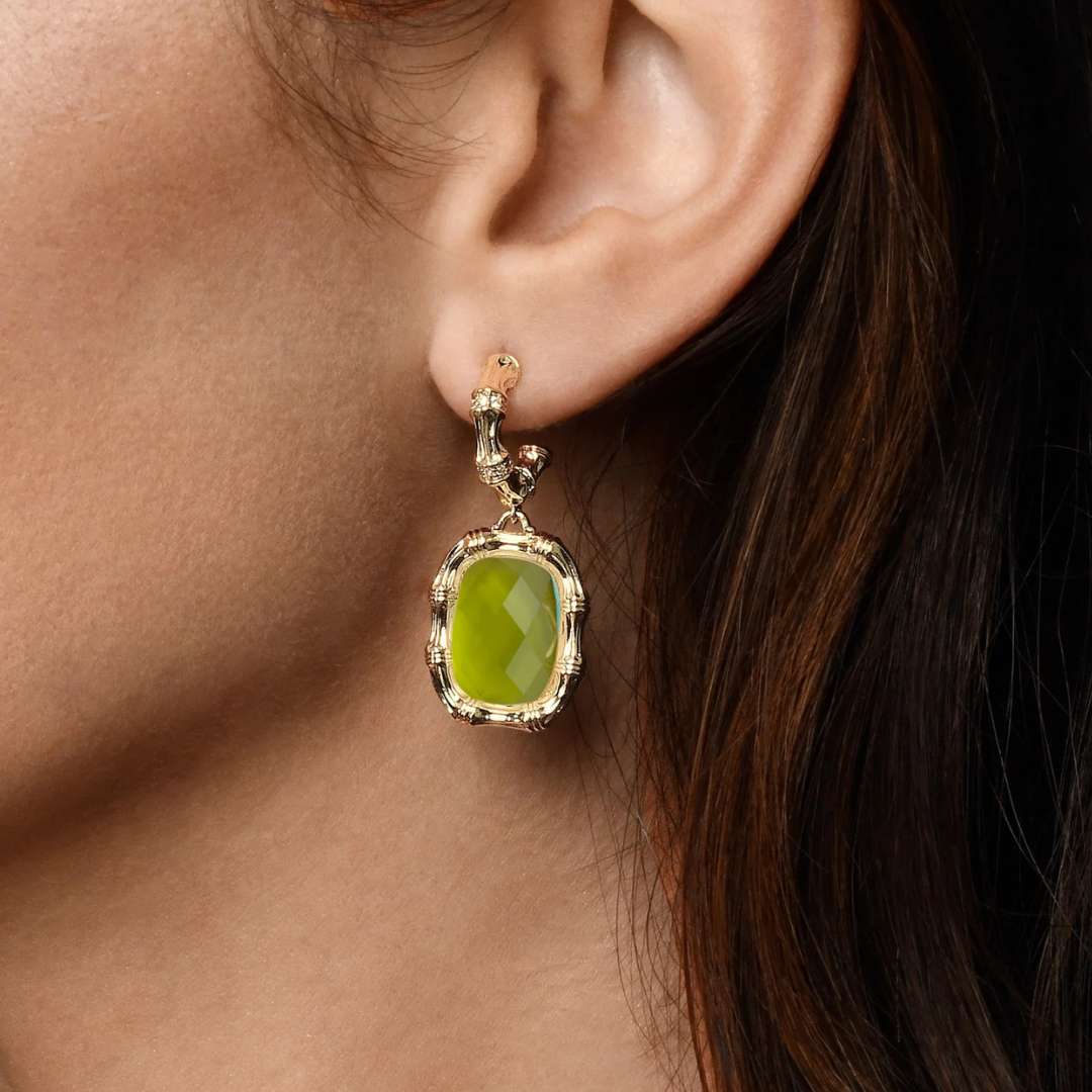 Close-up of an ear wearing a green gemstone earring.