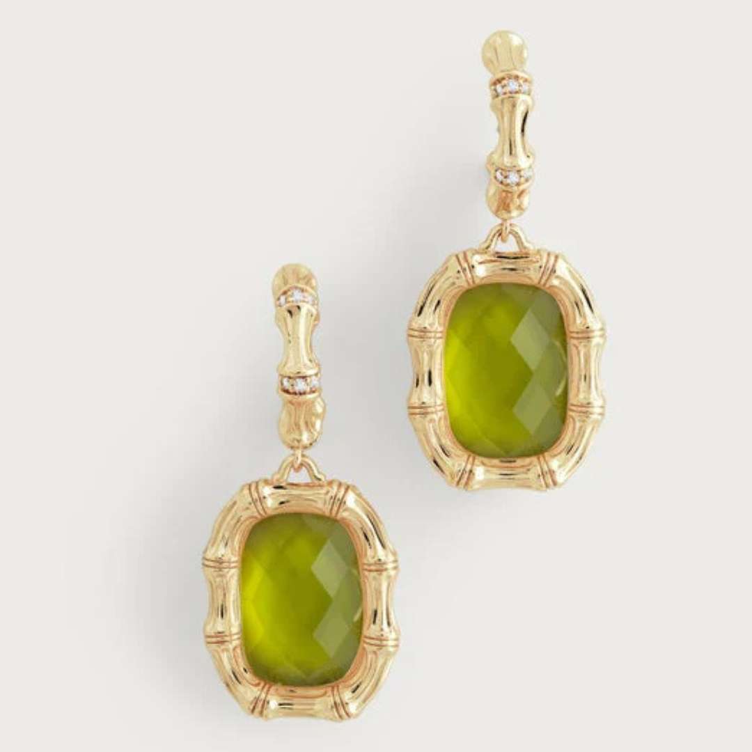 Gold earrings with green stones on a light gray background