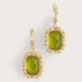 Gold earrings with green stones on a light gray background