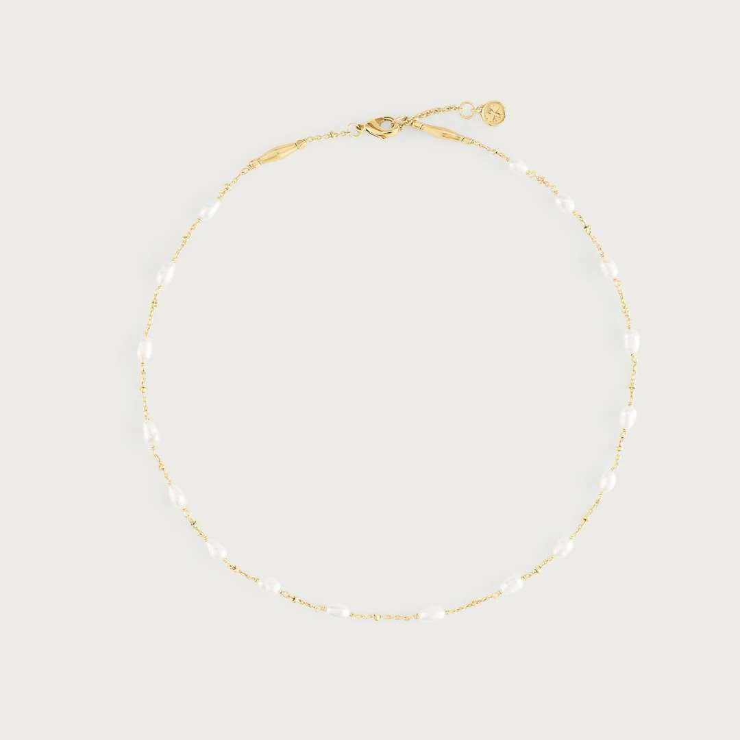 Gold necklace on a light beige background
