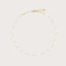 Gold necklace on a light beige background