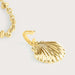 gold seashell charm on plain background