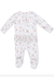 A baby footed long-sleeve romper in white with a delicate, all-over woodland print featuring deer, rabbits, and small flowers in muted pink, beige, and gray tones.