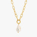 A gold paperclip chain necklace with a circular ring clasp holding a white baroque pearl pendant, shown against a plain white background.