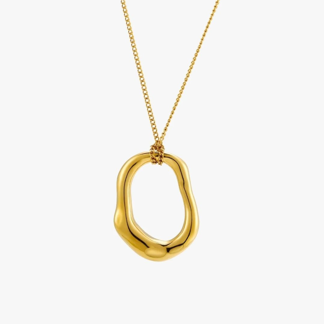 A gold abstract open pendant necklace on a delicate gold chain, shown against a plain light gray background.