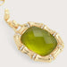 Gold pendant with a green stone on a light gray background