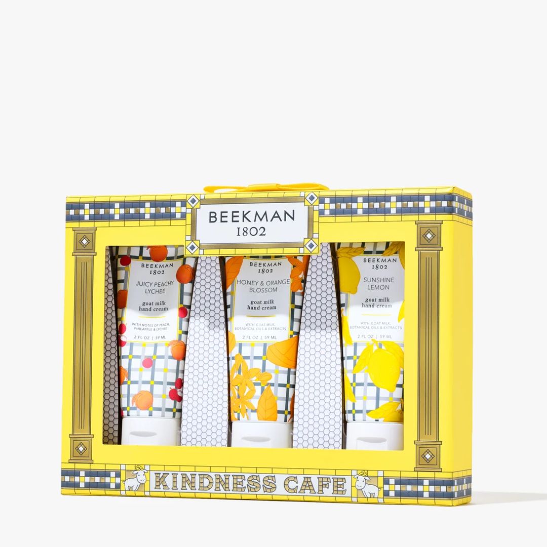 Beeman 1802 Kindness Cafe hand and foot care gift set in a bright yellow box with decorative gold and blue patterned trim, containing four tubes of hand and foot creams.