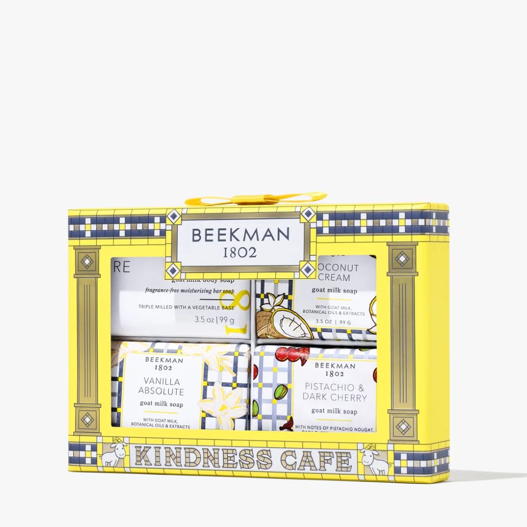 Beeeman 1802 Kindness Cafe gift set containing four goat milk soaps in a decorative yellow and navy blue box with illustrations of flowers, coffee beans, and cherries.
