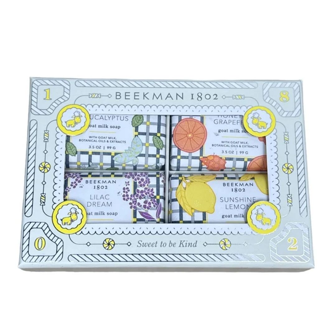 Beekman 1802 Sweet to be Kind gift set soap box, featuring four individually wrapped goat milk soaps with botanical illustrations of grapes, lilac, yellow lemon, and orange on a light blue patterned box.