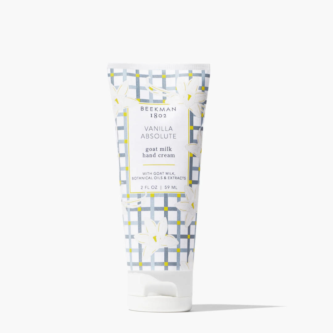 A squeeze tube of Beekman 1802 Vanilla Absolute goat milk hand cream, featuring a white and gray plaid pattern with white lily illustrations, on a clean white background.
