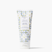 A squeeze tube of Beekman 1802 Vanilla Absolute goat milk hand cream, featuring a white and gray plaid pattern with white lily illustrations, on a clean white background.