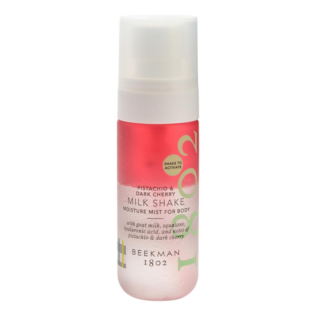 BEEKMAN 1802 Pistachio & Dark Cherry Milk Shake Moisture Mist in a frosted bottle with a white cap, featuring a pink and cherry-red label with green accents.
