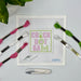 Cross-stitching kit with threads, needle, and scissors on a white surface