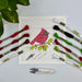 Cross-stitch kit with a red bird design, threads, and tools on a light gray background.