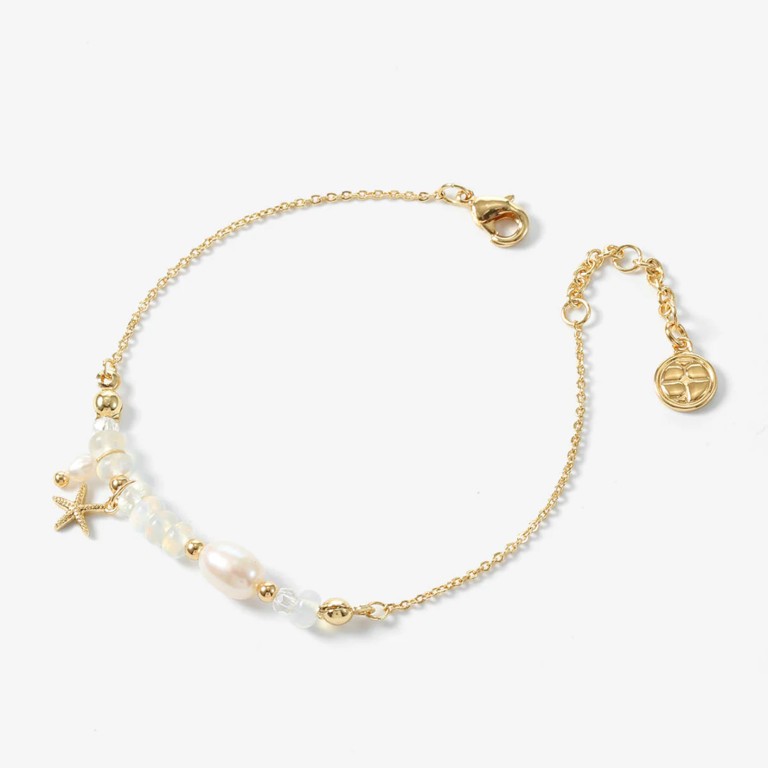 Gold bracelet with pearls on a white background