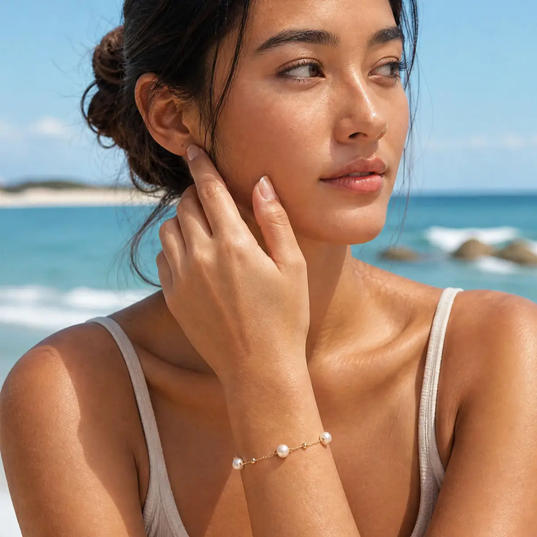 Woman on a beach with ocean view wearing a pearl bracelet