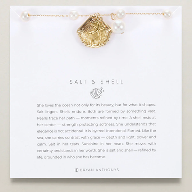 Gold shell necklace on a card with text and branding