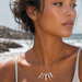 Woman wearing a necklace with a beach in the background
