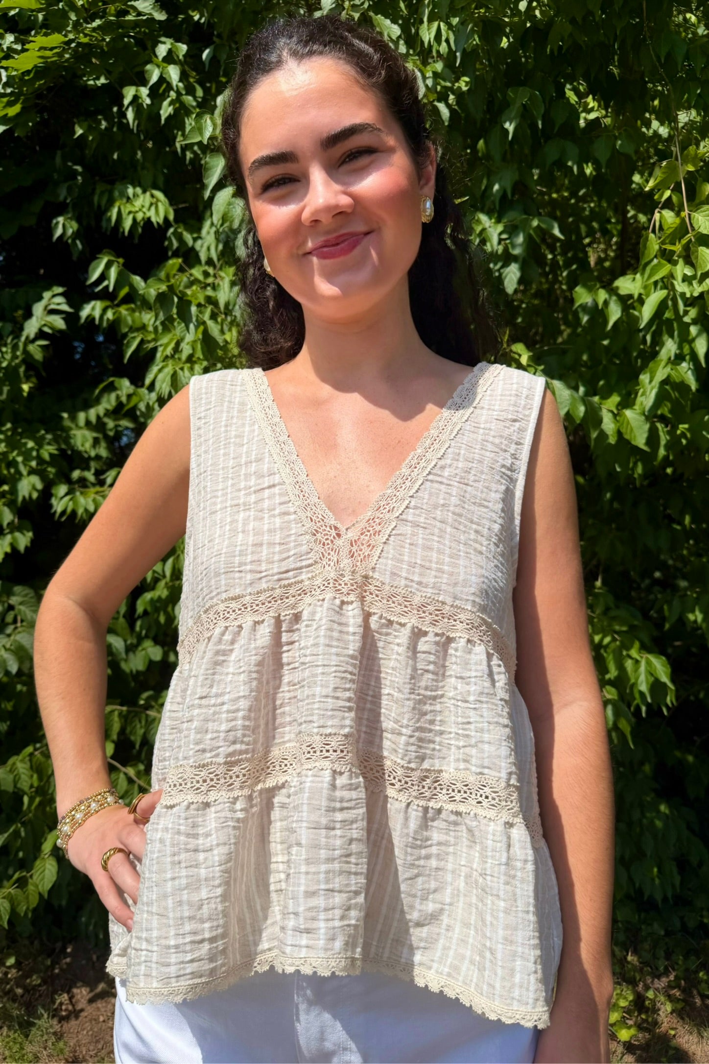 Woman wearing tan and white striped V-neck blouse