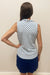 Woman wearing white half zip tank top with blue floral pattern detail 