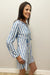 Woman wearing blue and white striped dress with lace up neck