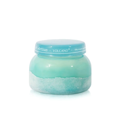 A round cosmetic jar with a light blue lid and a turquoise-to-white marbled gel or wax product inside, shown on a clean white background. The lid has the text 'Artisan VOLCANO' visible.