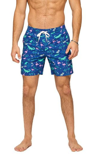 Man wearing blue swim shorts with animal pattern on a white background