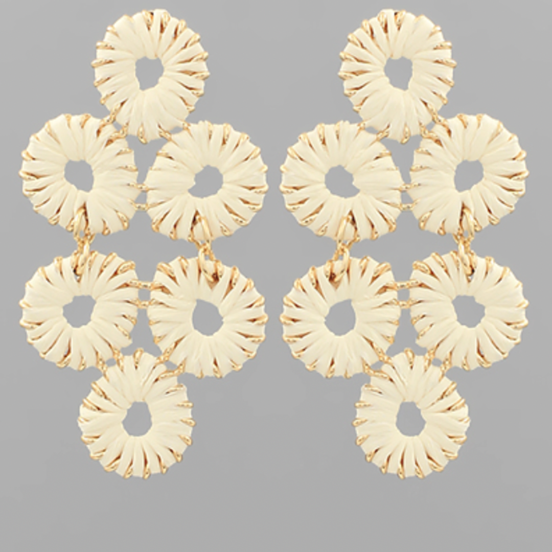 Pair of gold earrings with circular design on a gray background