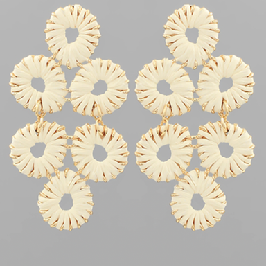Pair of gold earrings with circular design on a gray background