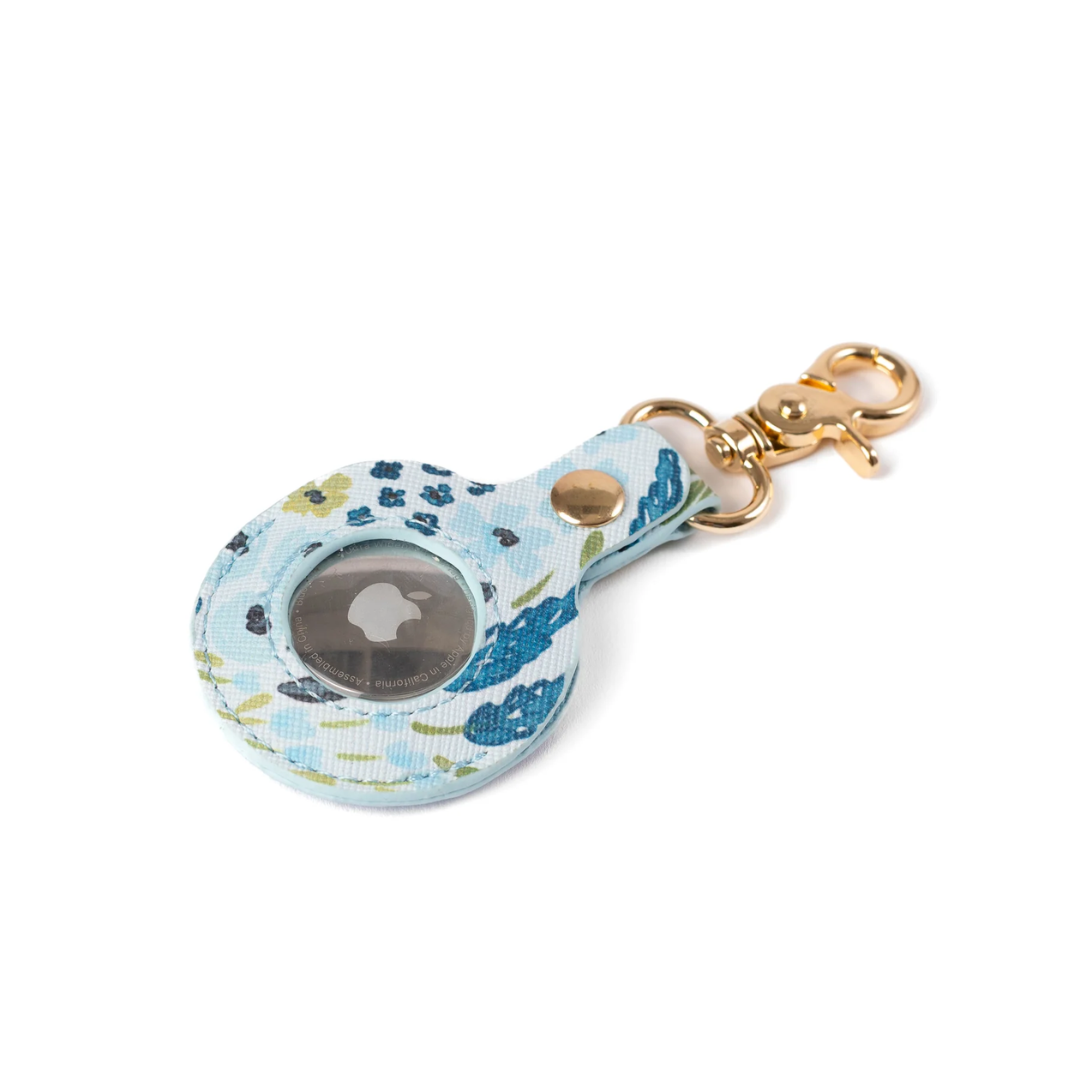 Floral patterned keychain case with a gold clasp on a white background