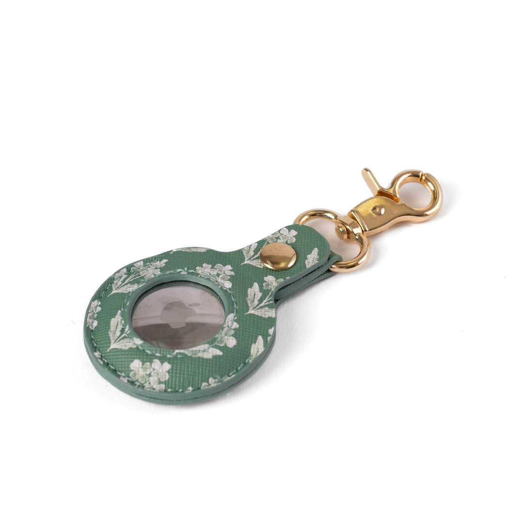 A green floral-patterned leather keychain pouch with a clear ID window, gold-tone hardware, and a lobster clasp, shown on a white background.