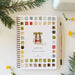 Camping watercolor workbook featuring a painted backpack surrounded by colorful watercolor swatches, styled with a paintbrush, evergreen branches and small yellow flowers on a light surface.
