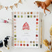 Farm watercolor workbook featuring a painted red barn and colorful watercolor swatches, styled with a paintbrush, watercolor paint, toy cow and horse, checkered bunting and dried wheat on a white surface.