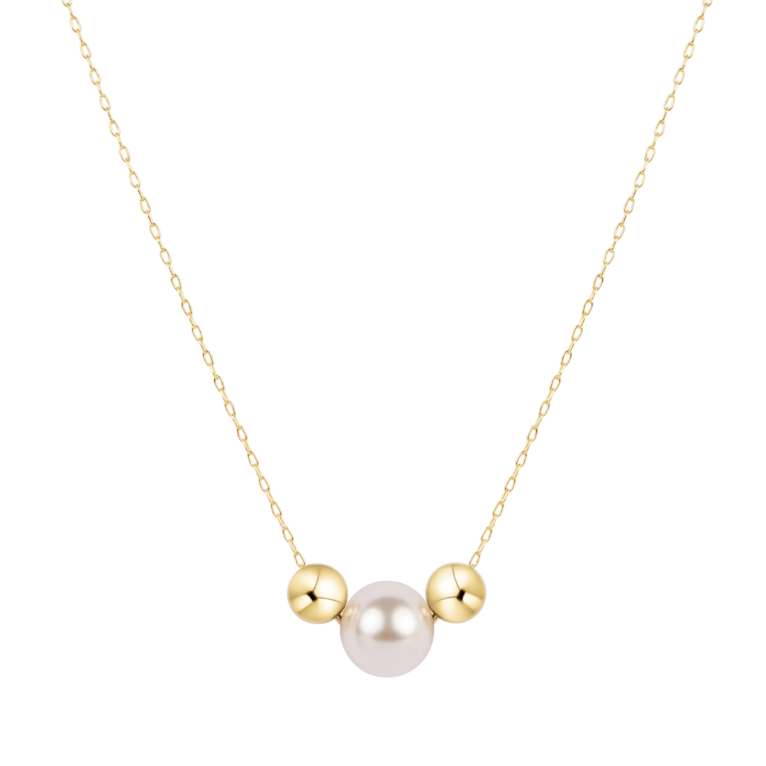 A delicate gold chain necklace featuring a central white pearl flanked by two small polished gold beads, set against a solid white background.