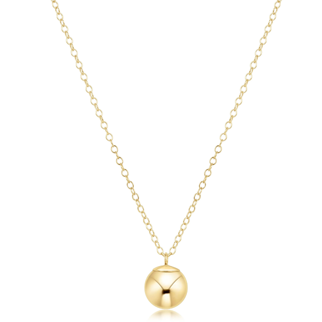A delicate gold chain necklace with a polished spherical pendant, displayed against a clean white background.