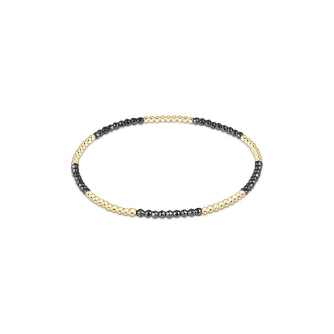Beaded bracelet with black and gold beads on a white background