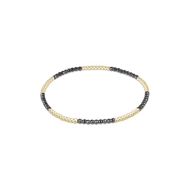 Beaded bracelet with black and gold beads on a white background