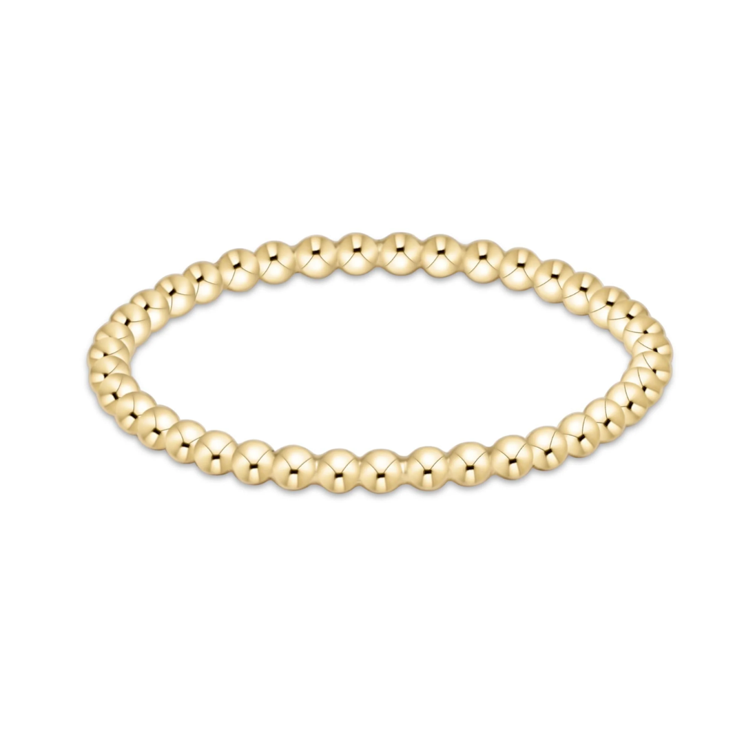 A gold beaded stretch bracelet with a polished, faceted bead design, shown against a plain white background.