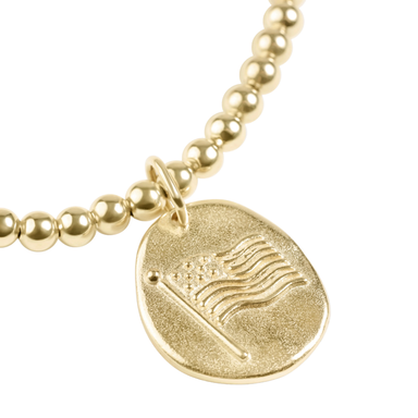 Gold beaded bracelet with a round pendant featuring an American flag design on a white background