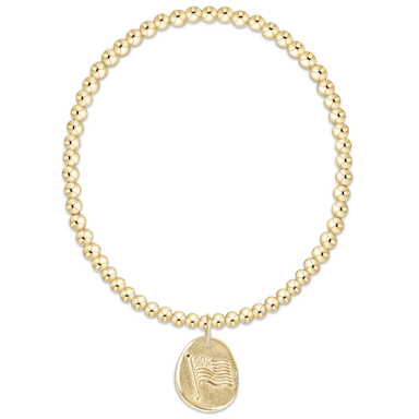gold beaded braclet with gold american flag charm against white background