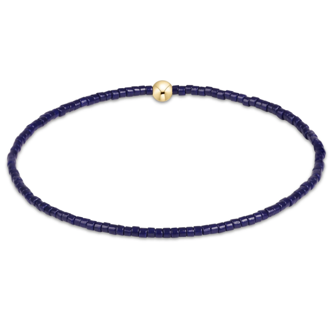 Navy blue beaded necklace with a gold clasp on a white background