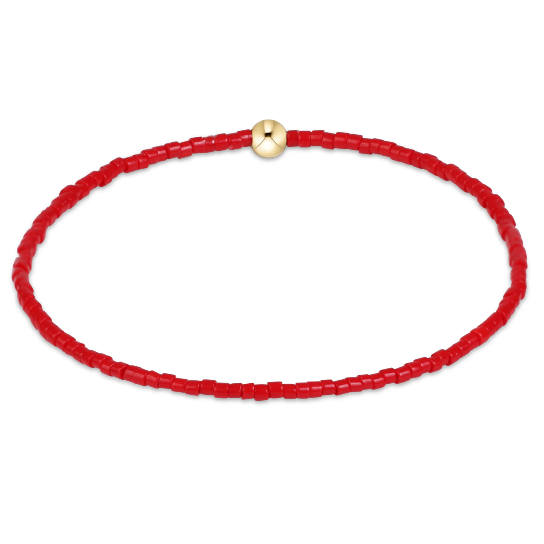 Red beaded necklace with a gold clasp on a white background