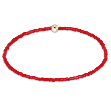 Red beaded necklace with a gold clasp on a white background