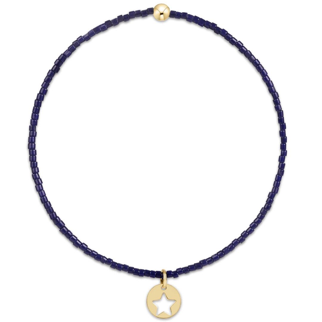 Navy blue beaded braclet with a gold star pendant on a white background