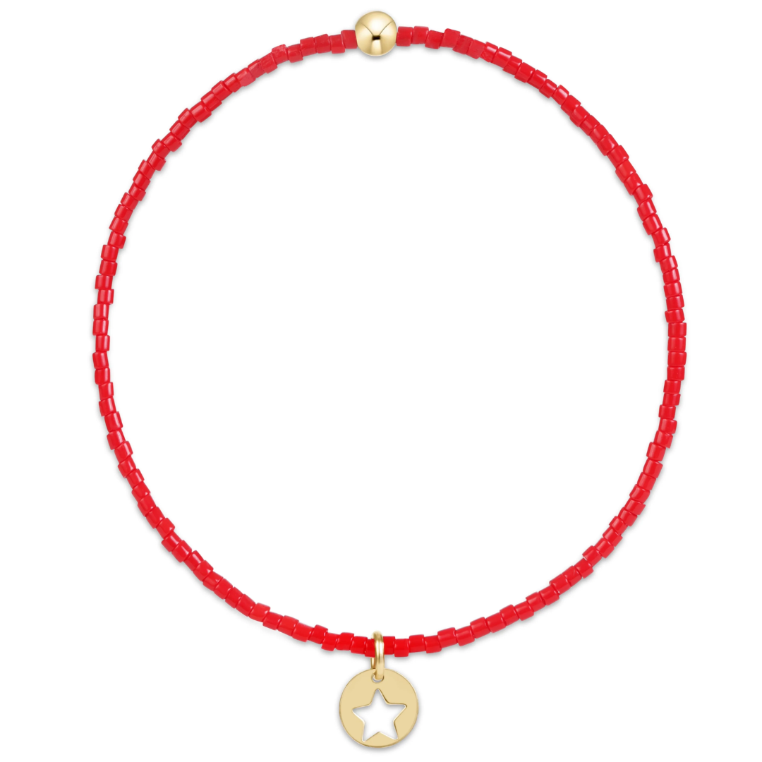 Red bracelet with a gold star charm on a white background