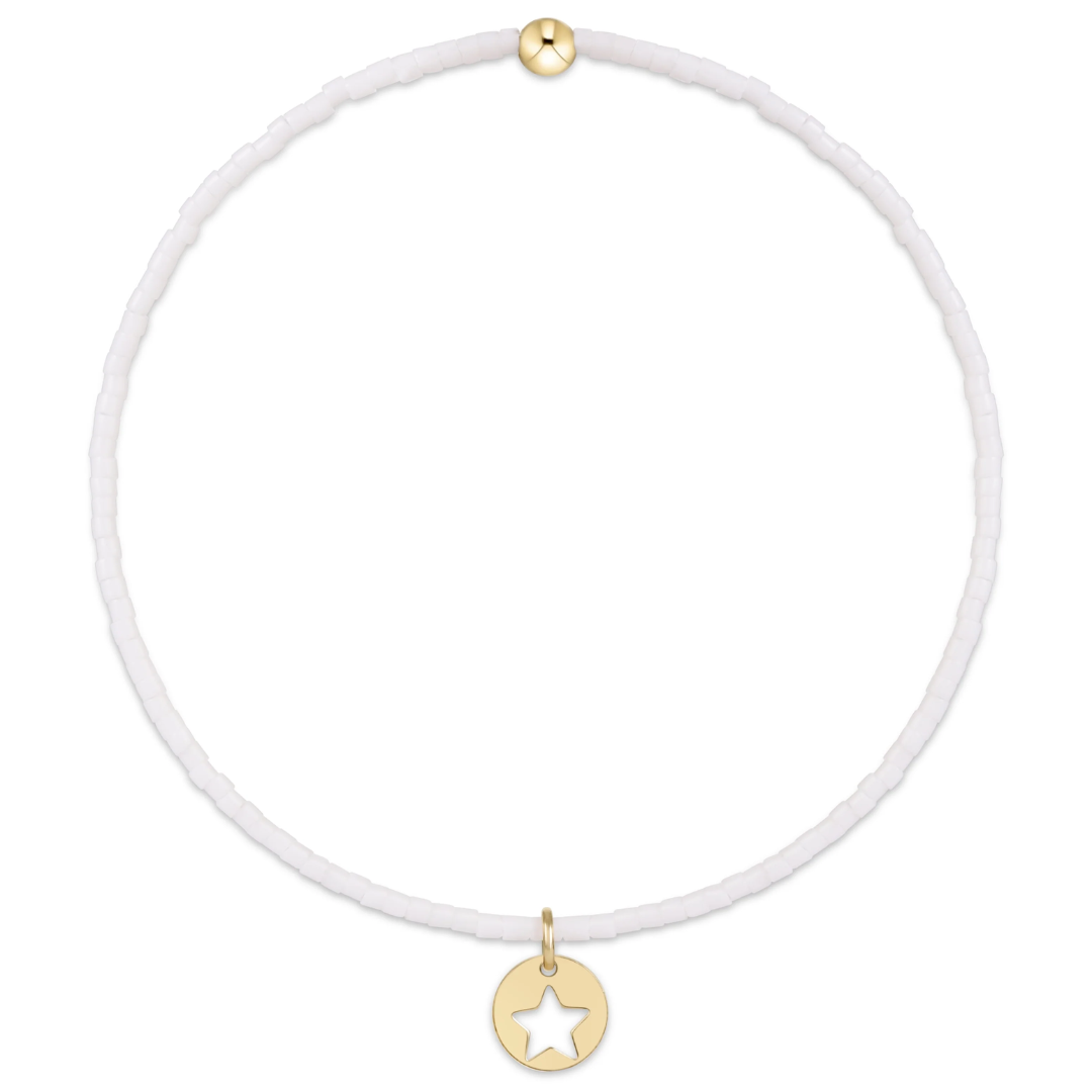 White braclet with gold star pendant on a white background