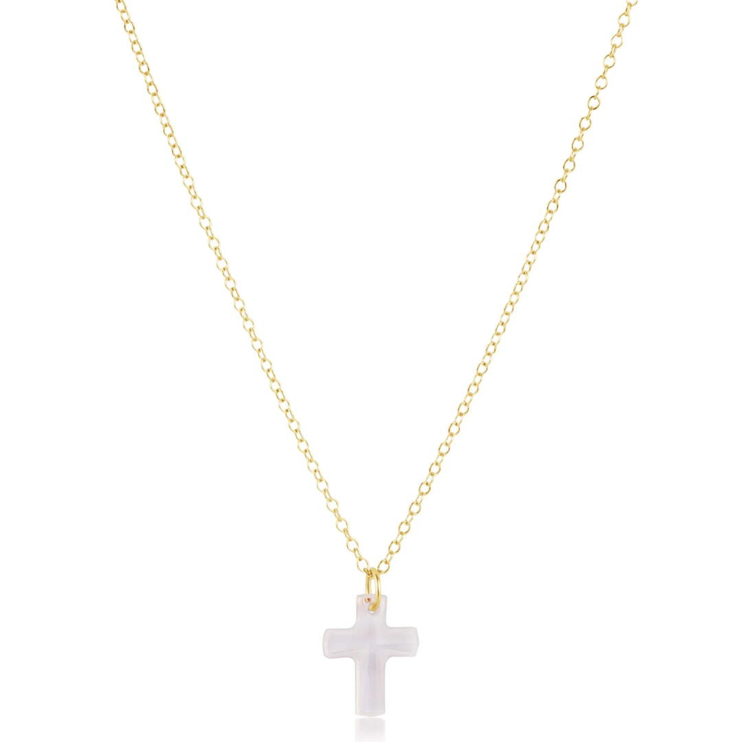 A delicate gold chain necklace with a small, polished white cross pendant, displayed against a solid white background.